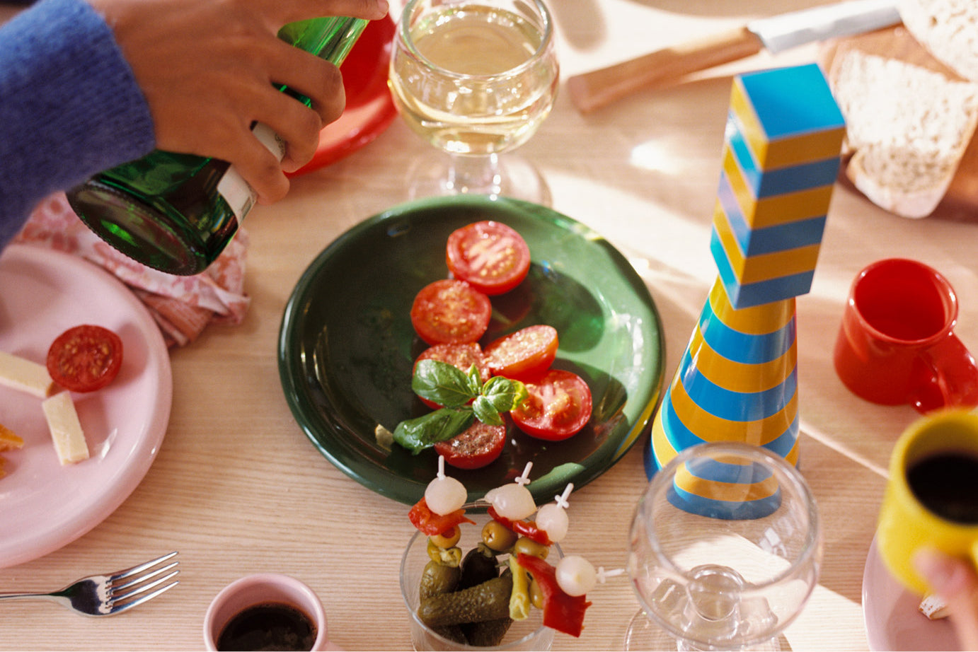 A lifestyle image of a dining scene featuring Molino Grinder and Bronto Tableware.