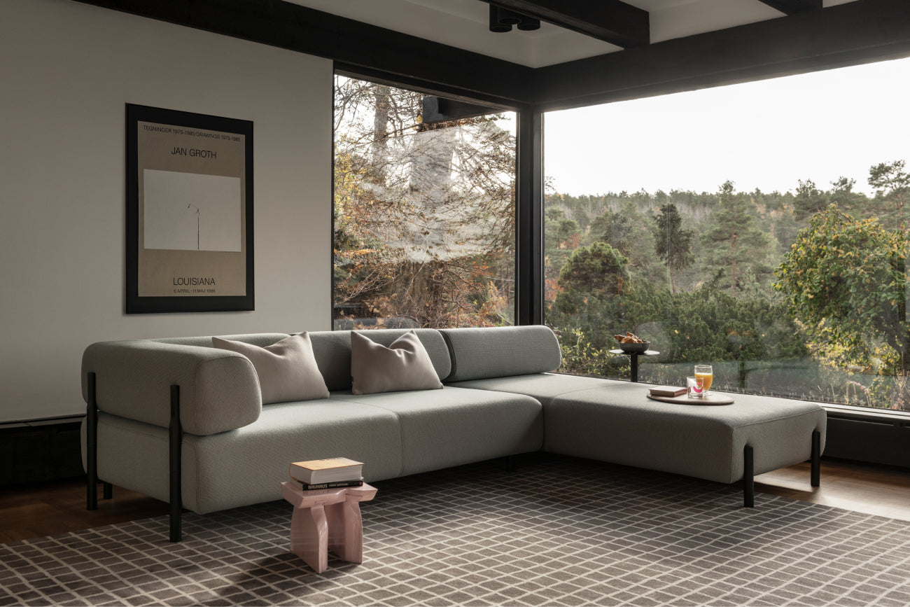 A living room scene featuring a Palo Modular Corner Sofa Right in Beige and a Grid Rug Large.