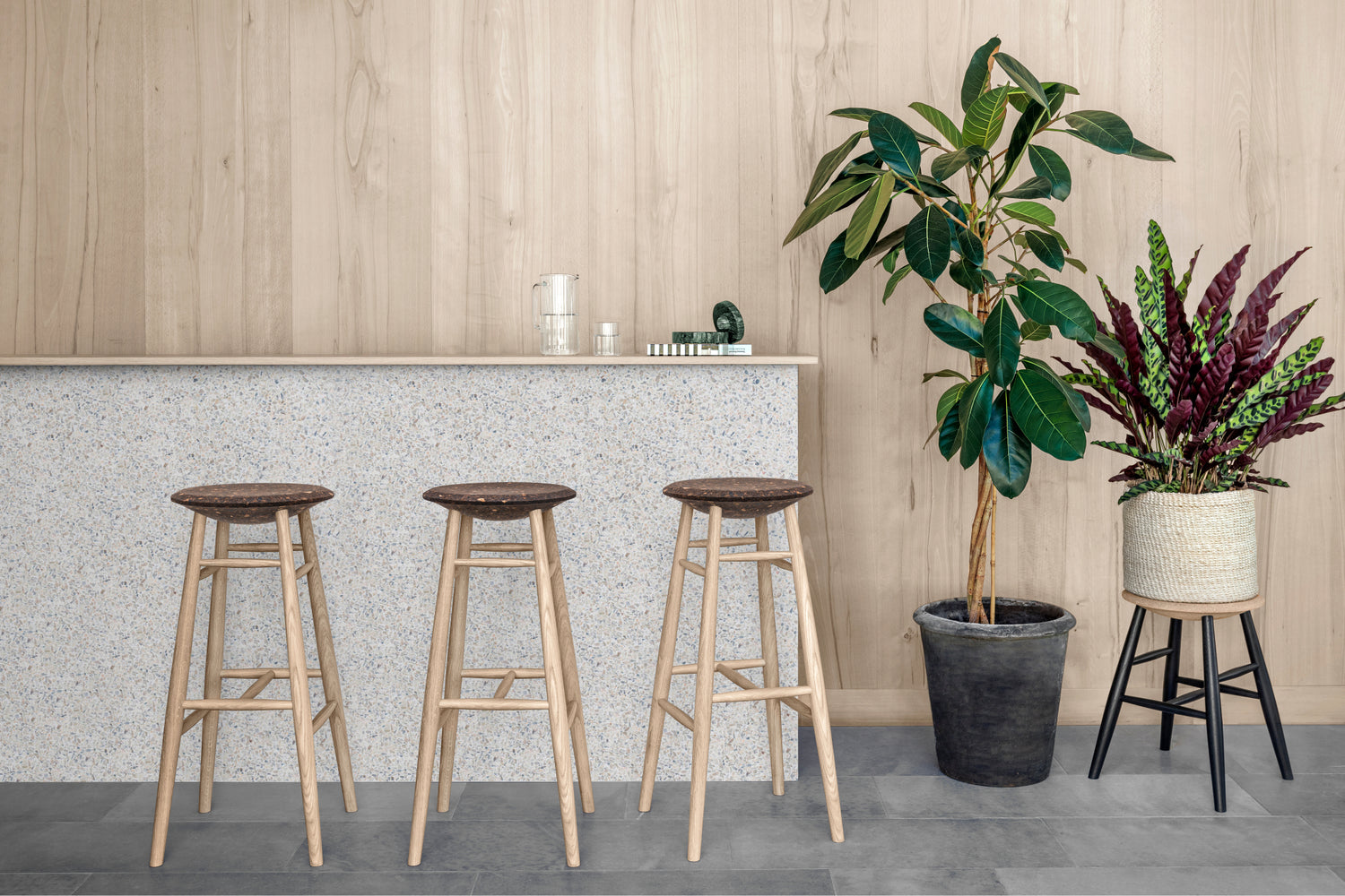 A  lifestyle image of a dining area featuring Drifted Bar Stool and Drifted Stool.