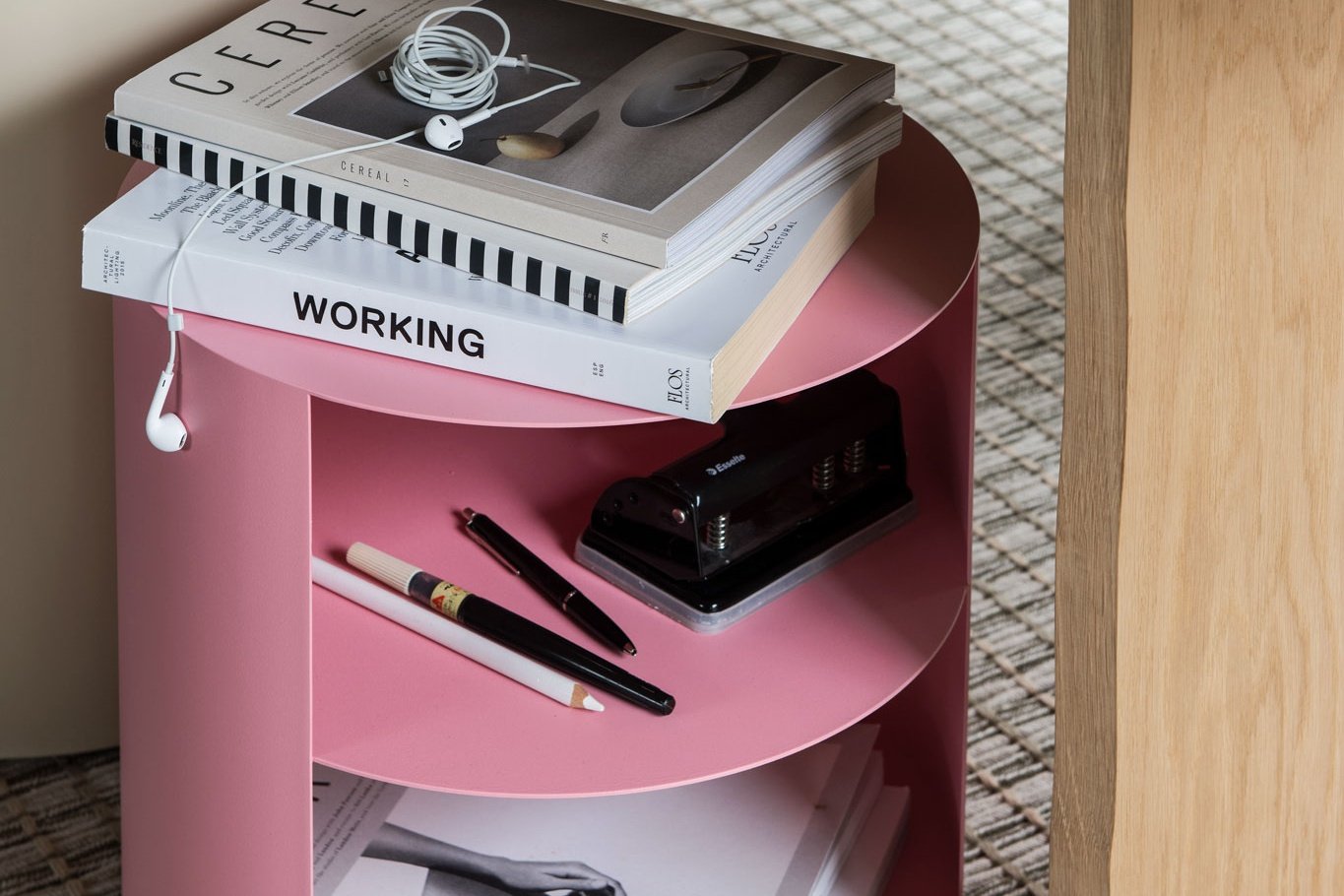 A Hide Side Table in the shade Light Pink being used as storage for books, pens and more on top of a Seaweed Rope Rug