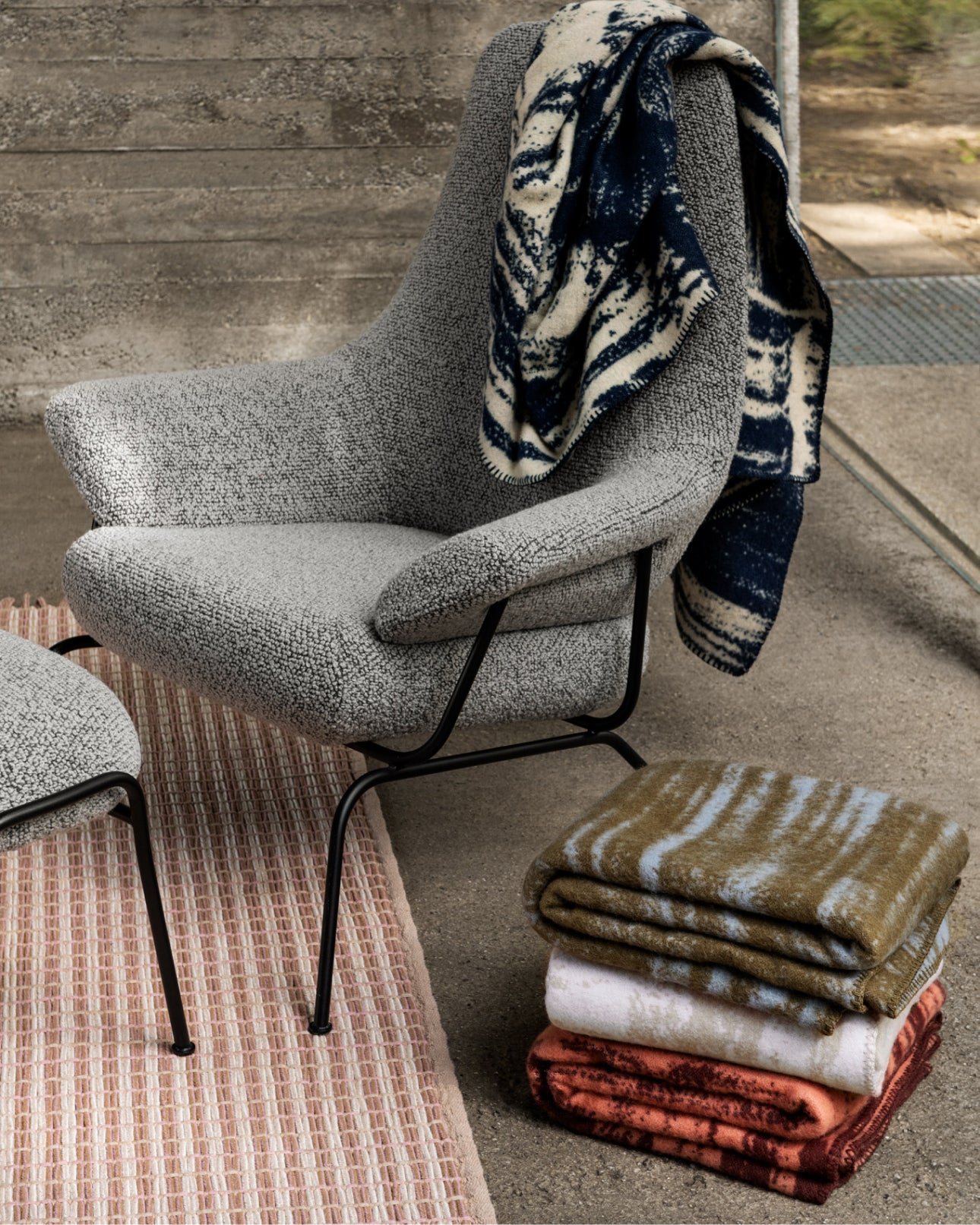 A Hai Lounge Chair + Ottoman in Pebble with Glitch Throws and a Rope Rug in Rose Quartz.