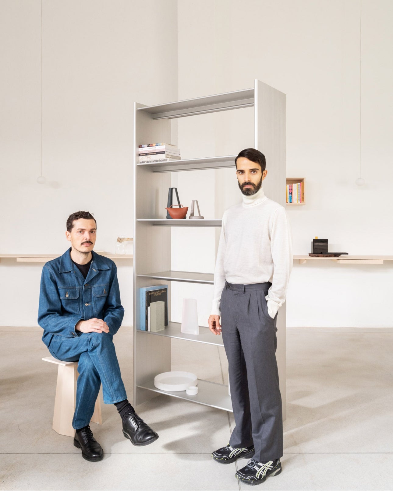 An image of Formafantasma, the designers of the T Shelf, with a T Shelf High 100 in the background.